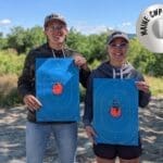 Two people holding up blue bags with a target on them.