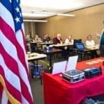 A man standing in front of an american flag.