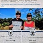 Two people holding certificates in front of a forest.
