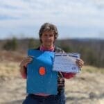 A woman holding an envelope and paper in her hands.